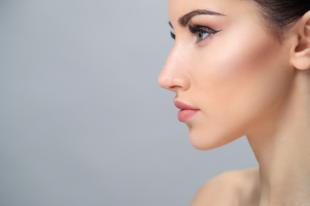 perfil de mujer con maquillaje natural y fondo gris