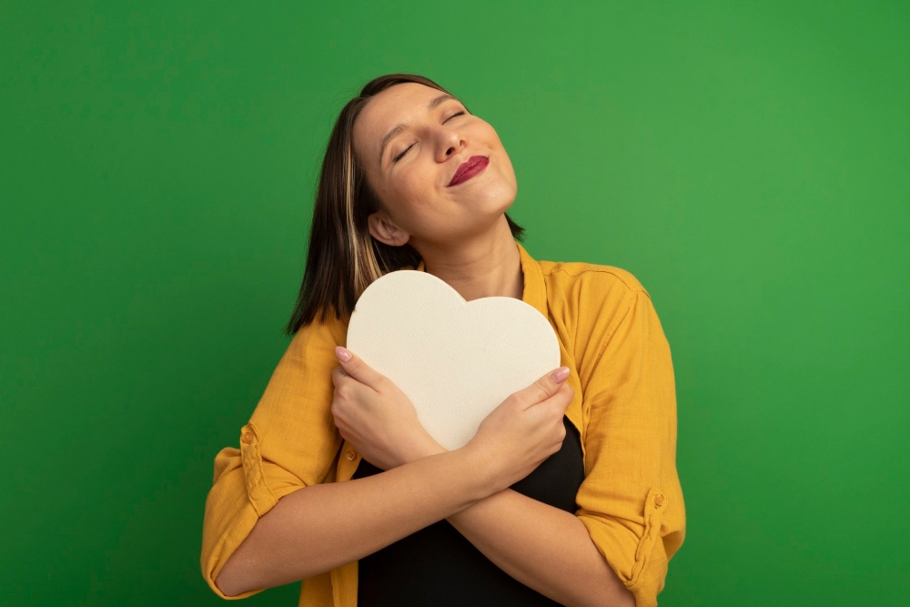 mujer abrazando un corazon de carton