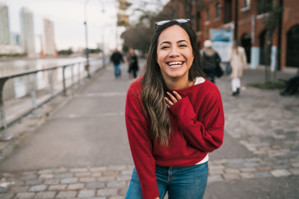 mujer con jersey rojo sonriendo labioplastia